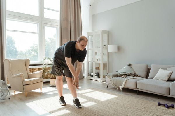 Man stretching in a bright living room